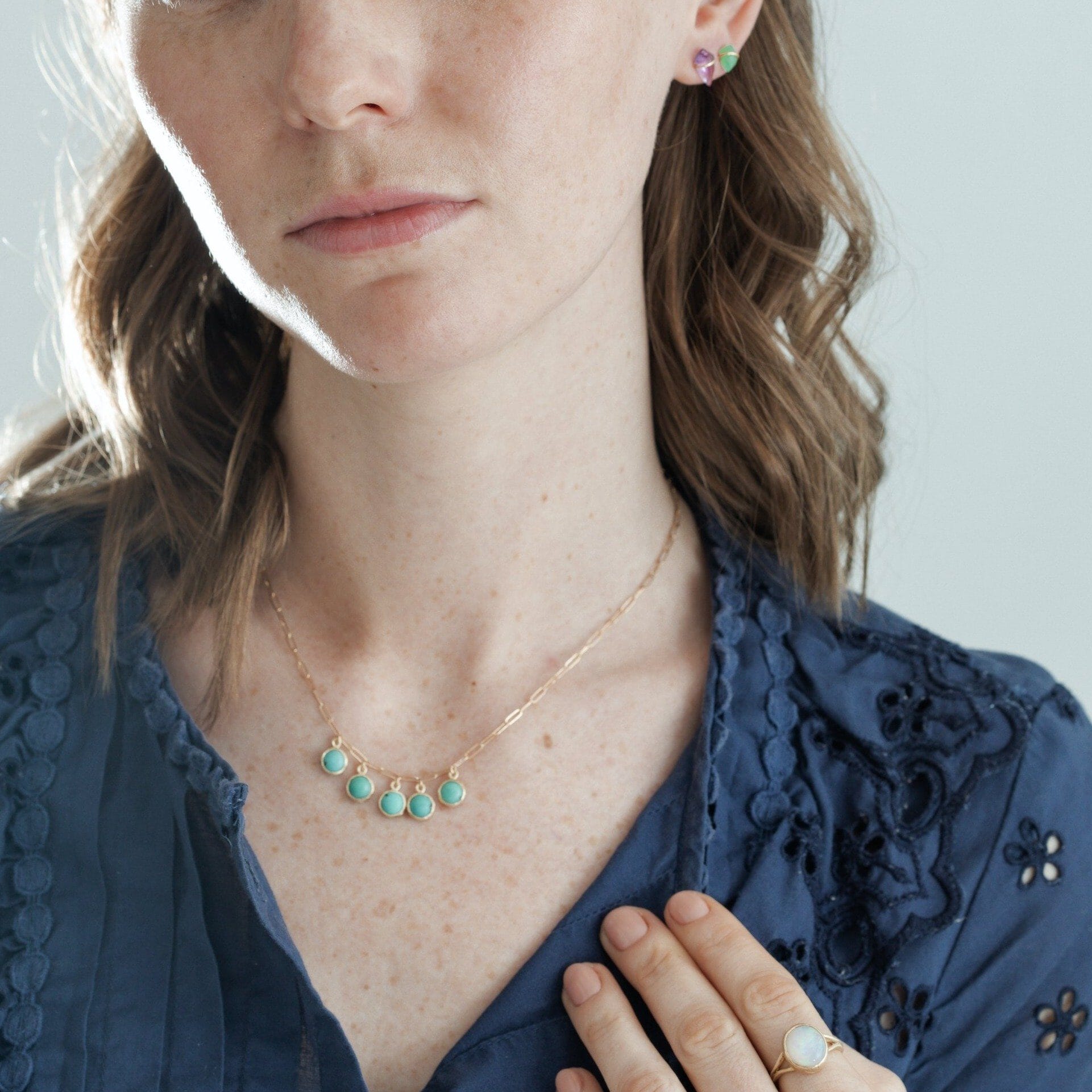 Model wearing handmade necklace with five turquoise drops in 10kt gold