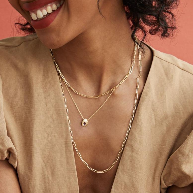 Model wearing Handmade oval sapphire necklace in 18kt gold.